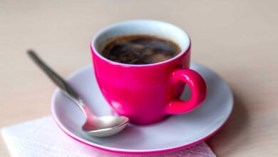 Cafe Espresso fumegante em uma xicara de cafe rosa vibrante