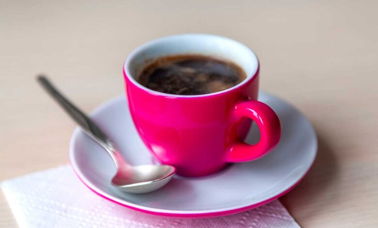 Cafe Espresso fumegante em uma xicara de cafe rosa vibrante