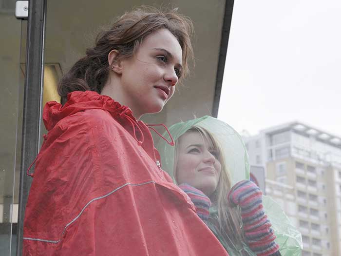 2-young-women-in-raincoats-at-bus-stop-nualaimages